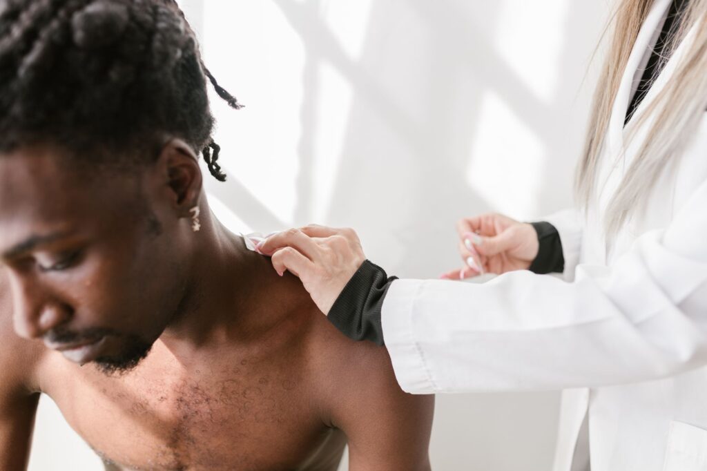 Close-up of a man receiving a shoulder massage for pain relief indoors, physical therapy newnan ga