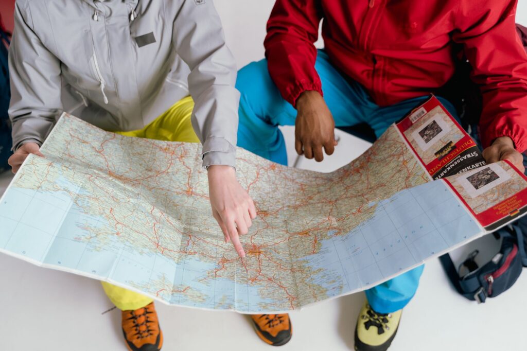 Two travelers examining a detailed map for a winter hiking adventure, physical therapist columbus ga