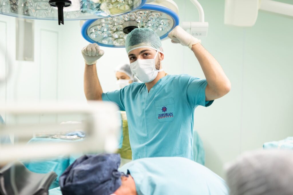 A surgeon in scrubs celebrates after a successful surgery in an operating room, how pt helps after joint replacement surgery